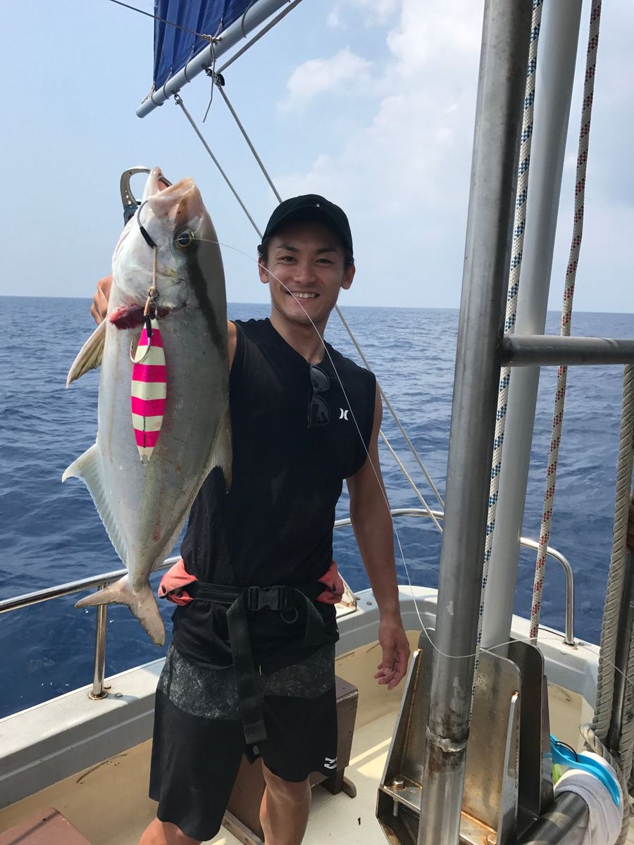 船の上で、釣った魚を掲げているところ