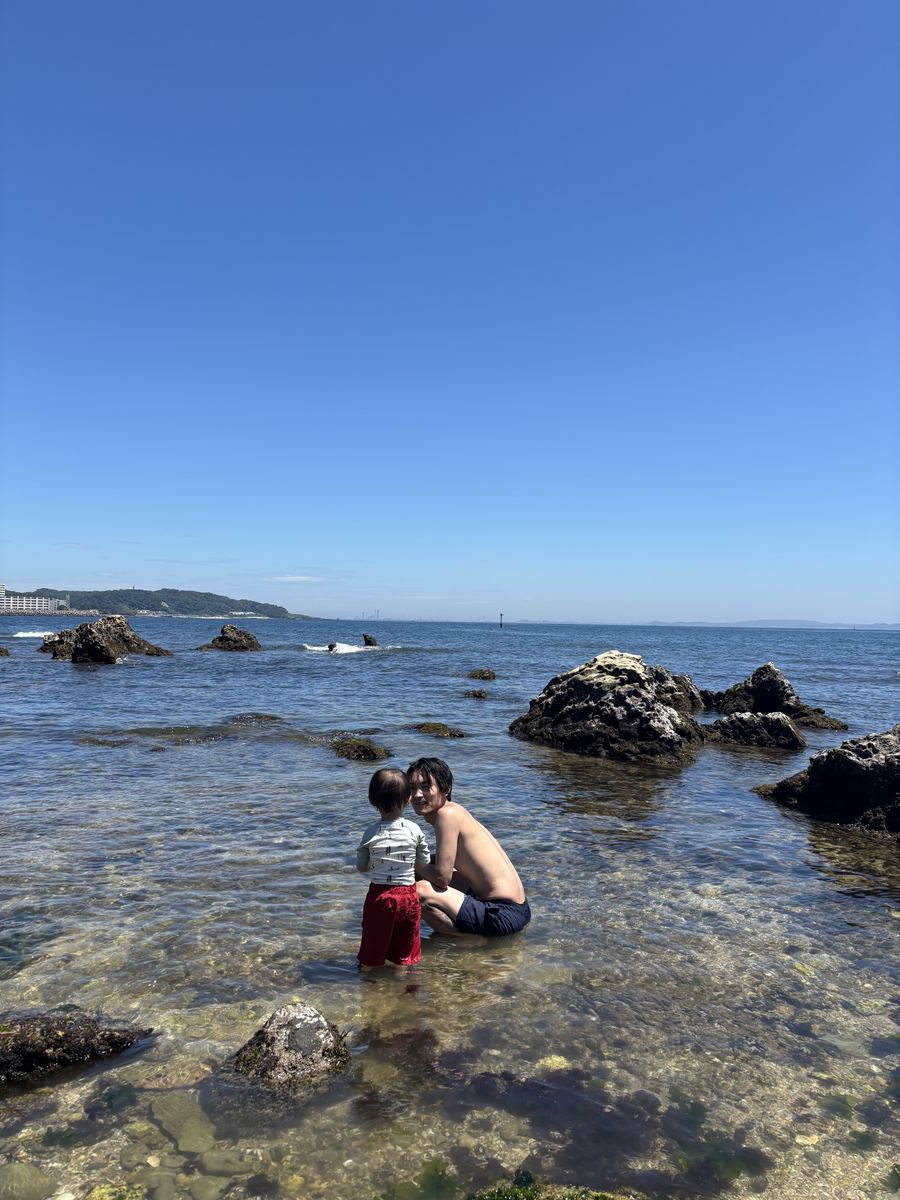 海辺の岩場で、子どもと水遊びをしているところ